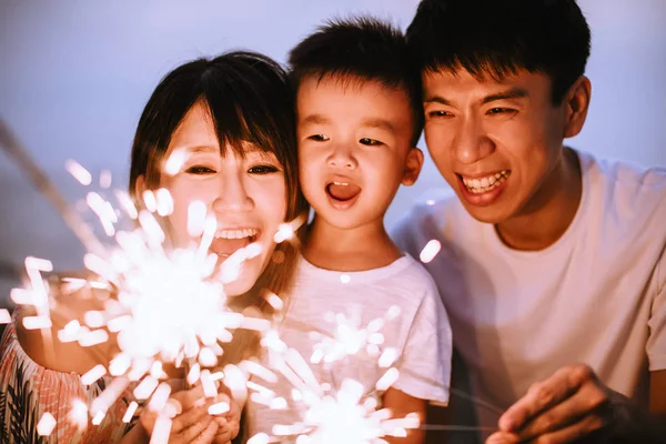 Família feliz celebrando o ano novo com sparklers — Fotografia de Stock