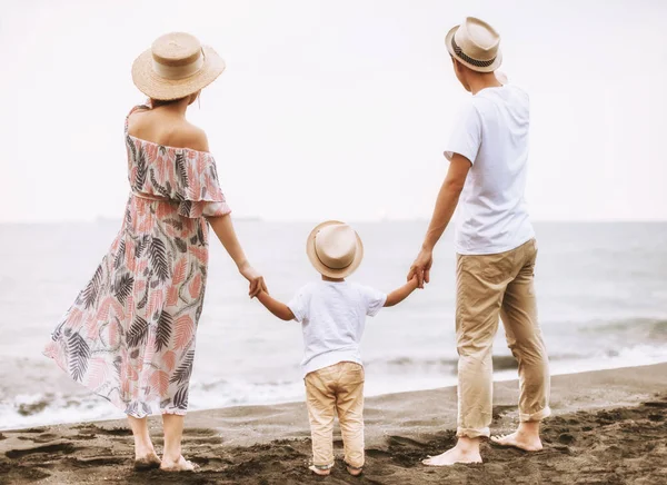 Rear view happy  family standing on the beach  watching  sunset — Stock Photo, Image