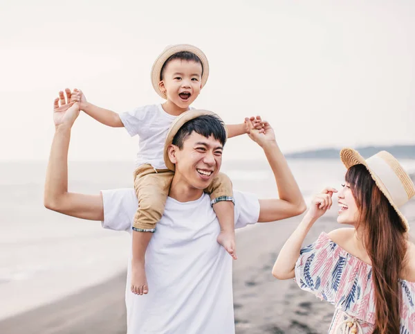 Mutlu Asyalı aile gün batımında sahilde oynuyor. — Stok fotoğraf