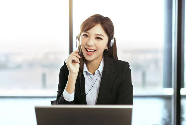 Joven mujer de negocios con auriculares en la oficina —  Fotos de Stock