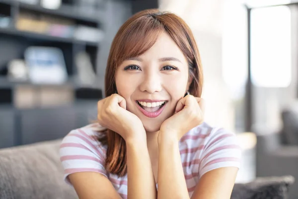 Sorridente giovane donna seduta sul divano — Foto Stock