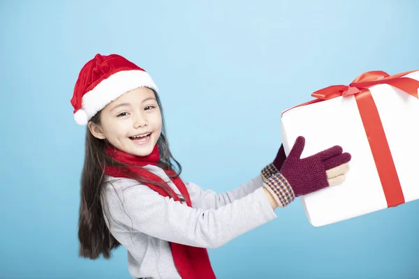 Heureuse petite fille dans chapeau de Père Noël et tenant boîte cadeau — Photo