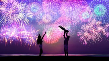 Mutlu bir aile kumsalda oynuyor ve havai fişekleri seyrediyor.