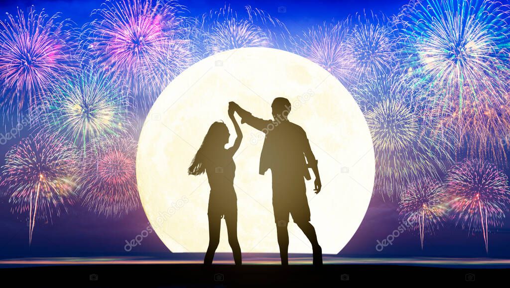 Happy Romantic young Couple dancing on the beach and watching the fireworks