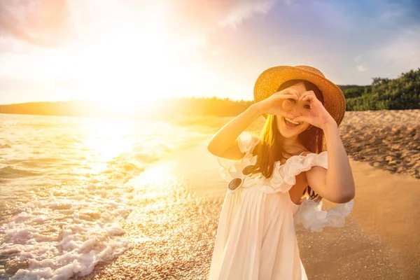 Szczęśliwa Młoda Kobieta Robi Gest Serca Plaży Zachodzie Słońca — Zdjęcie stockowe