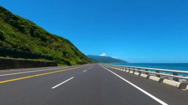 Dağ ve kıyı şeridi otobanında mavi gökyüzü arka planına sahip sürüş. POV