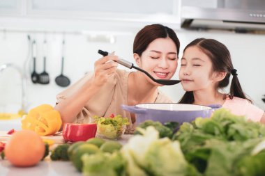 Mutlu anne ve çocuk Saucepan 'dan Aroma kokuyor.