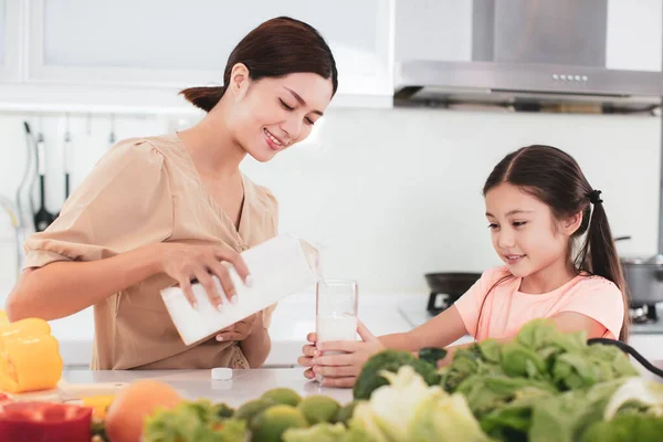 台所で母親と子供が牛乳を飲むと — ストック写真