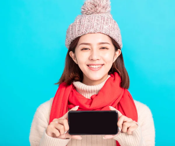 Glimlachende Jonge Vrouw Winter Jurk Toont Smart Phone — Stockfoto