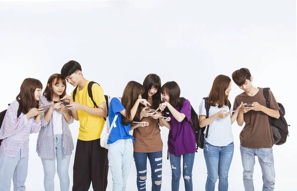 Grupo Estudiantes Jóvenes Mirando Teléfono Móvil Pie Juntos — Foto de Stock