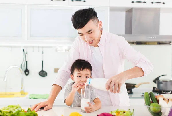 父と息子は台所でミルクと朝食を持っています — ストック写真