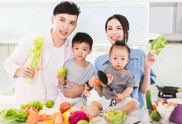 快乐的家庭在厨房里展示健康的食物 — 图库照片