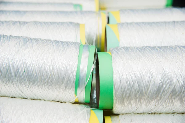 Textile industry - yarn spools on spinning machine in a textile factory