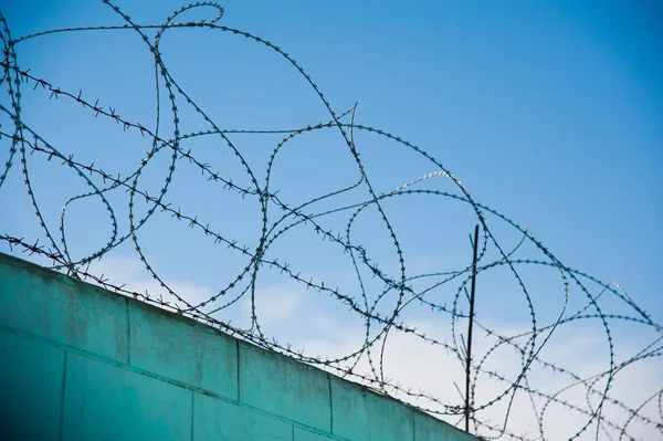 Hapishane duvarlarının etrafına dikenli teller gerilmiş.