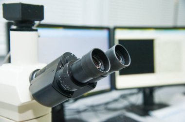 Laboratuvarda metal mercekle mikroskobun yakın çekim görüntüsü.