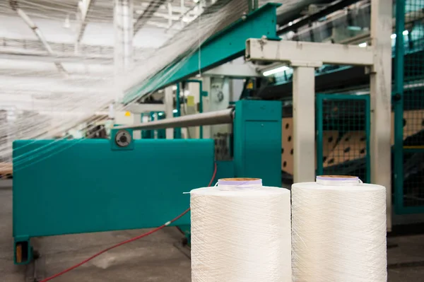 Textile industry - yarn spools on spinning machine in a textile factory