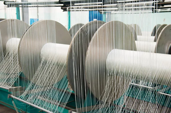 Textile industry - yarn spools on spinning machine in a textile factory