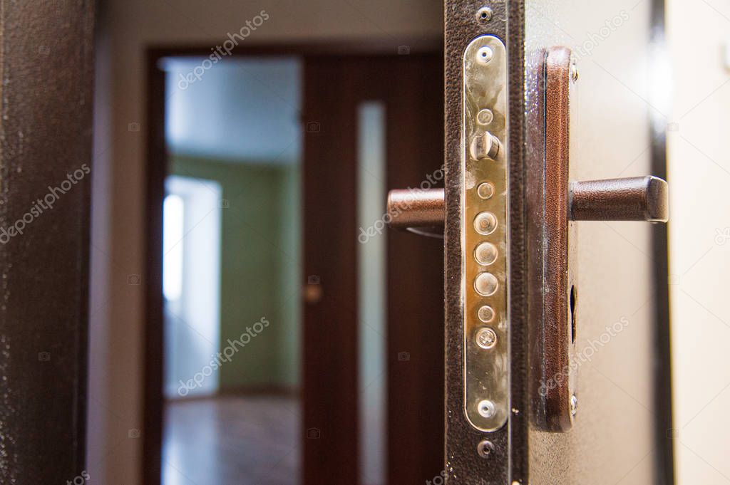 Half opened door to a empty room. Door handle, door lock.