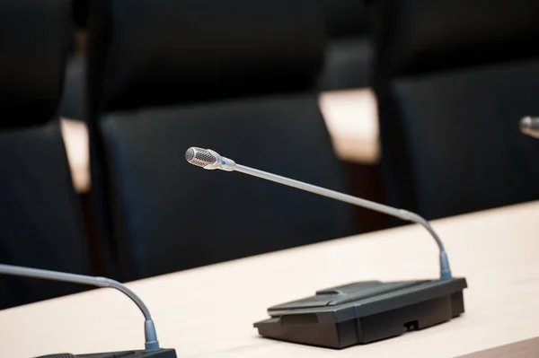 Before a conference, the microphones in front of empty chairs