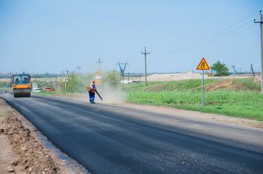 Yol yapımı, sanayi ve takım çalışması üzerine çalışan işçiler, yeni asfalt