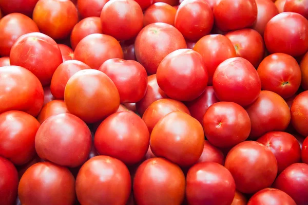 Fresh ripe tomatoes in a box for sale in the grocery shop. Tomatoes in a box as a background