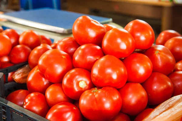 Fresh ripe tomatoes in a box for sale in the grocery shop. Tomatoes in a box as a background