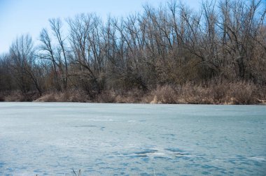 Erken baharda ormandaki nehir sessizce akan akar olduğunda hala buz ve kar. Bahar manzara