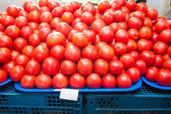 Fresh ripe tomatoes in a box for sale in the grocery shop. Tomatoes in a box as a background