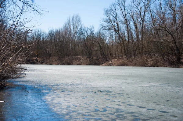 Erken baharda ormandaki nehir sessizce akan akar olduğunda hala buz ve kar. Bahar manzara
