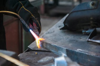 Fabrikada çalışan kaynakçılar metal üretiyorlar.