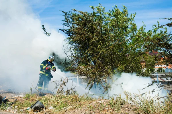 Bombero apaga un fuego —  Fotos de Stock