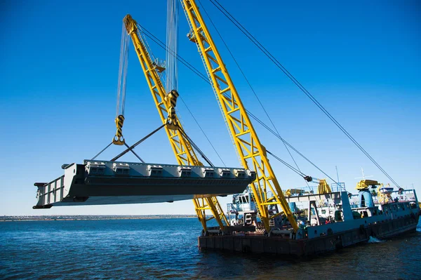 Loading in port. Floating port crane on blue sky background