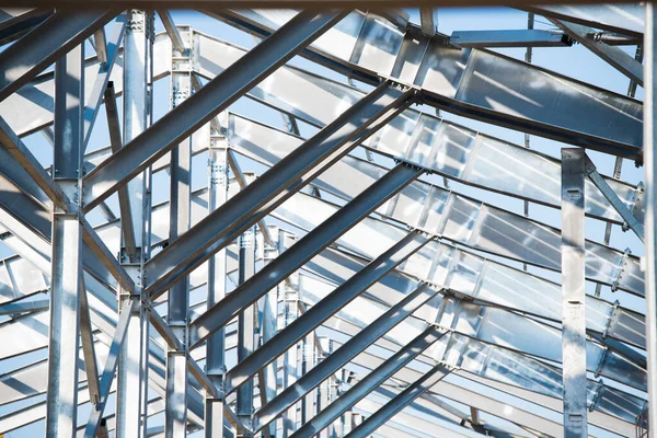 Steel frame workshop is under construction against a blue sky