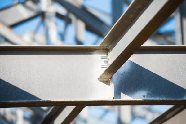 Steel frame workshop is under construction against a blue sky