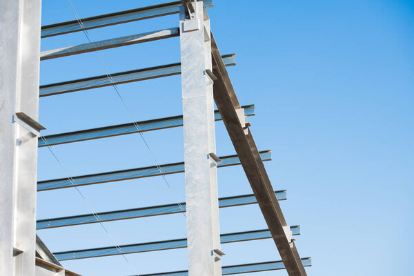 Steel frame workshop is under construction against a blue sky. New technology steel frame for construction