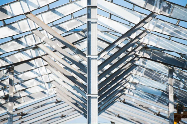 Steel frame workshop is under construction against a blue sky