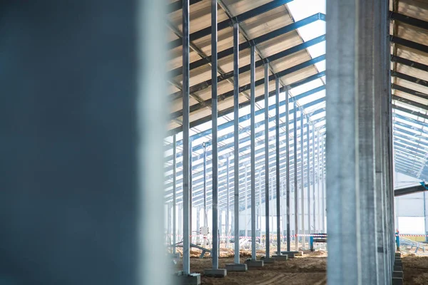 Steel frame workshop is under construction against a blue sky