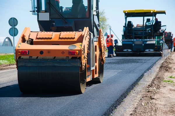 Yol yapımı, sanayi ve takım çalışması üzerine çalışan işçiler, yeni asfalt