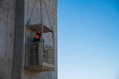 Nehir boyunca bir yol köprüsünün inşaatı. İnşaat alanında inşaat malzemeleri ve inşaat malzemeleri var. Mavi gökyüzüne karşı köprünün desteği.