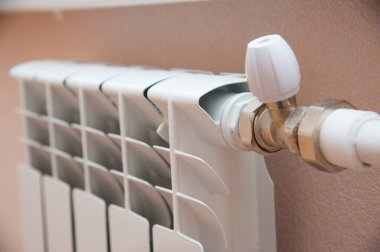 Duvarda yeni beyaz bir radyatör var. Evde ısıtma.