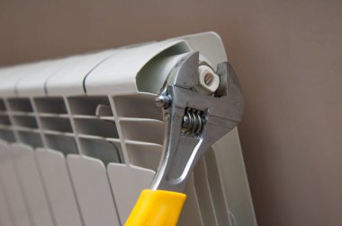 Servis elemanı elleri radyatörün yanında ingiliz anahtarıyla