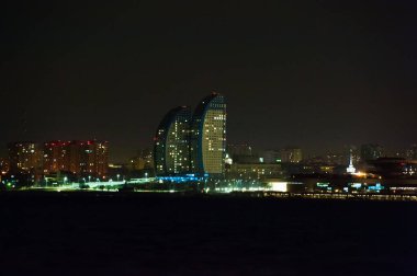 Gece şehrin panoraması. Nehir önplanda.