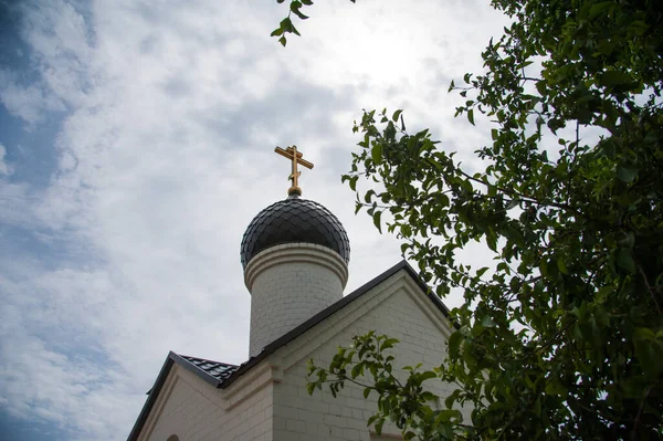 青空を背景に十字架を持つ黄金のドーム教会 — ストック写真