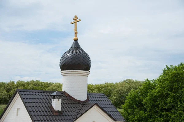 Golden domes church with a cross on a background of blue sky