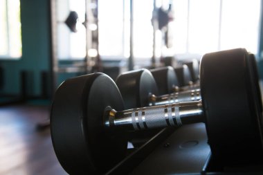 Modern spor salonunun içi ekipmanlarla dolu. Halterler, dambıllar, koşu bantları, kardiyo ekipmanları
