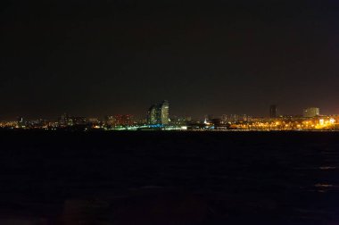 Gece şehrin panoraması. Nehir önplanda.