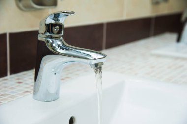 Umumi tuvalette, restoranda, otelde veya alışveriş merkezinde modern beyaz seramik lavabo.