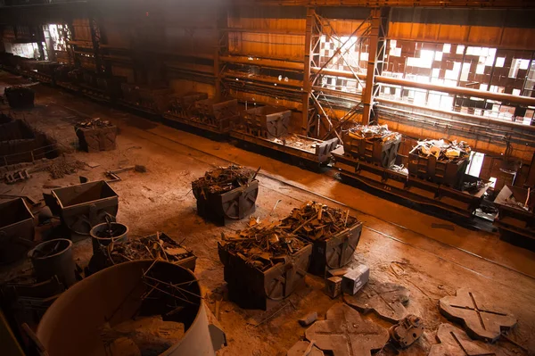 Metal structures and buildings of the old metallurgical plant inside and outside. The process of melting metal. Steelworker at work. Products of the metallurgical enterprise.