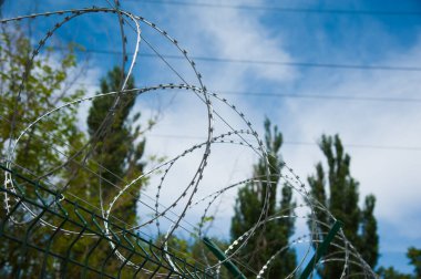 Hapishane duvarlarının etrafına dikenli teller gerilmiş.