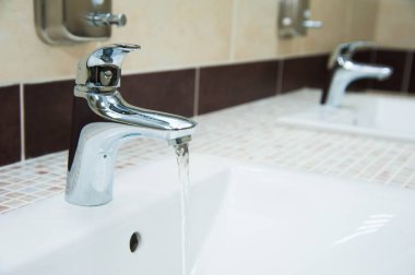 Umumi tuvalette, restoranda, otelde veya alışveriş merkezinde modern beyaz seramik lavabo.